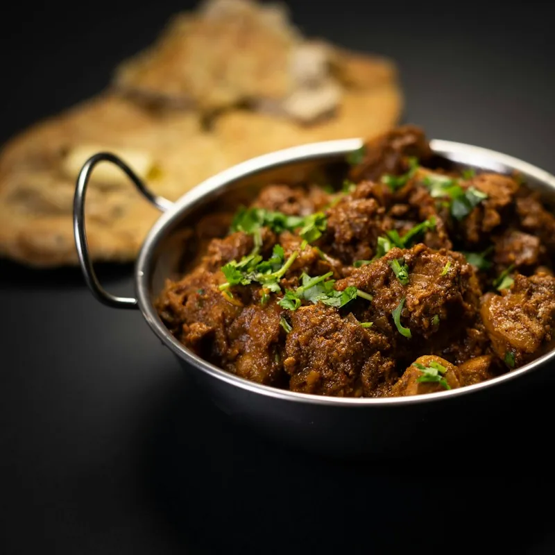 Dry meat curry in a steel kadai